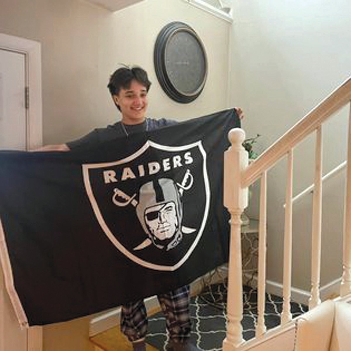 CHRISTMAS GIFT: Less than a month before her death, Olivia Passaretti holds a Las Vegas Raiders banner she received as a Christmas present.